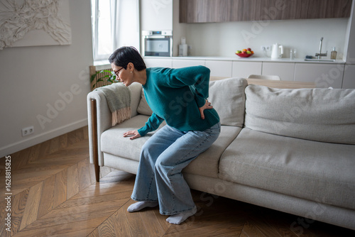 Obraz na plátně Lonely pensioner woman holding spine in agony due to sharp back pain