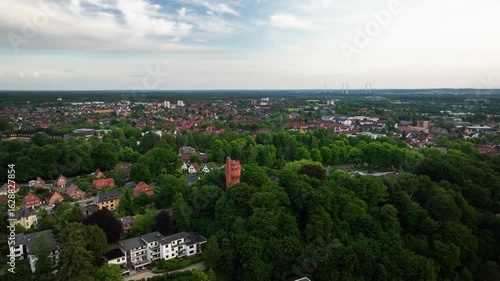 Aerial orbit of water tower in spa park of Mölln the Eulenspiegel town and residential areas. Red brick water tower nestled within the spa park of Mölln and the surrounding town areas.