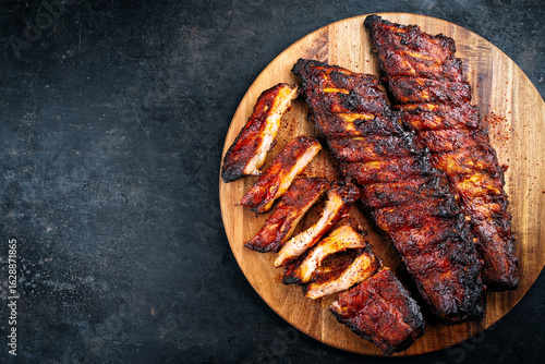 Barbecue tandori masala pork spareribs St Louis cut with hot rub served as top view on a wooden cutting board