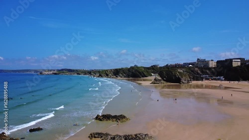 Long coastline with waves, cliffs, and distant beach town