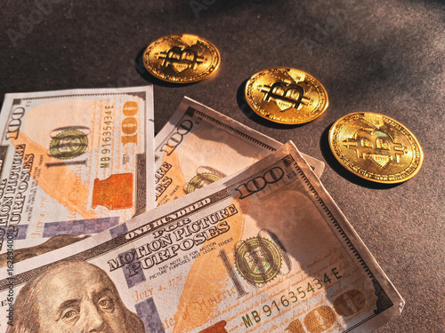 Billede på lærred Golden Bitcoin coins placed on prop US dollar bills