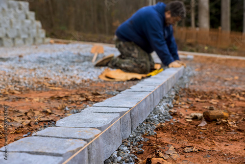 Εκτύπωση καμβά Construction worker carefully places cinder blocks on gravel to create pathway