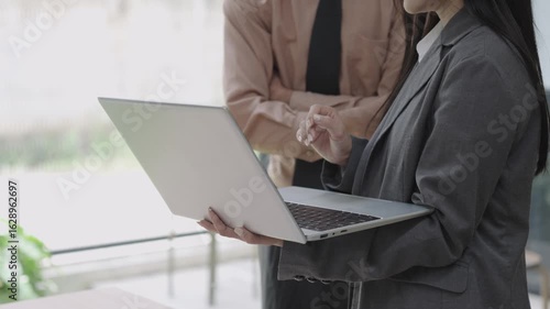 Asian businesswoman explaining document on blank white tablet in conference room using computer, talking, discussing and solving business problems faced.