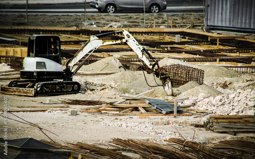 Fototapeta premium an urban area under construction with an excavator centered around building materials and traffic in the background. industry and development design element