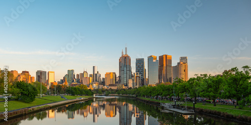 Фотография The city buildings in downtown Melbourne, Victoria, Australia are reflected in the calm water of the Yarra River at sunrise