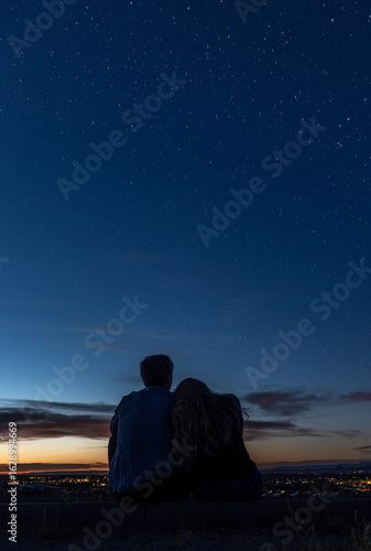 Wallpaper Mural A man and a woman sit under a starry sky, enjoying each others company Torontodigital.ca