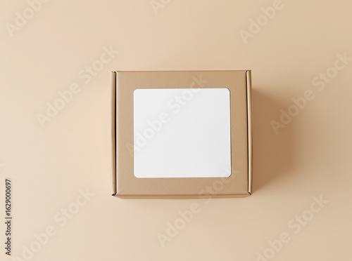 Cardboard box with blank label mockup on beige background