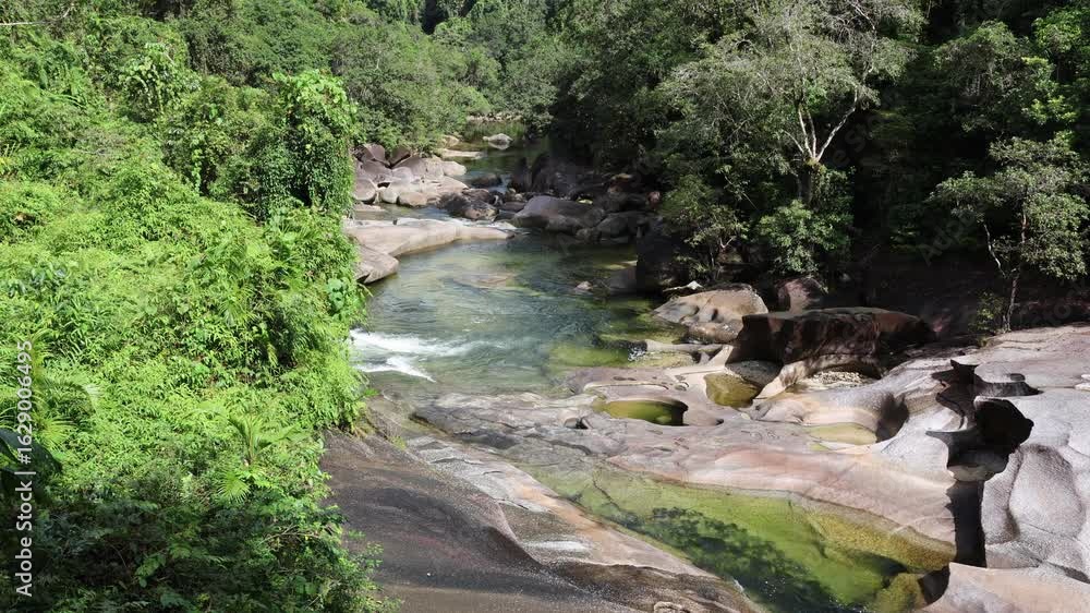 River of water running through a tropical rainforest at Babinda Boulders in Queensland, Australia River of water running through a tropical rainforest at Babinda Boulders in Queensland, Australia