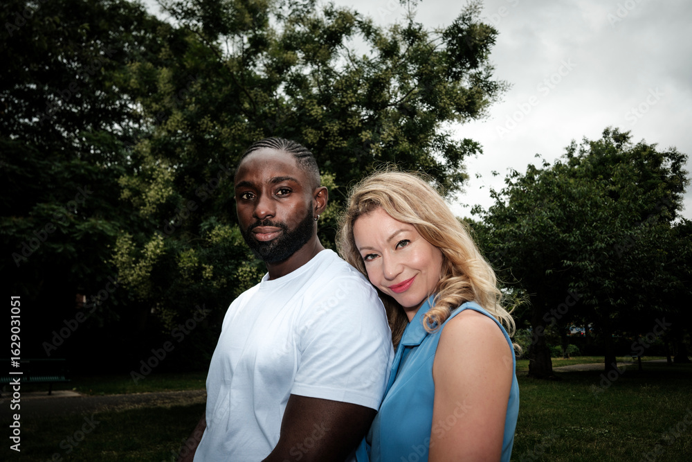 Obraz premium Interracial couple posing together in park during summer day