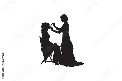 Elegant silhouette of a bride having her makeup applied by a maid of honor or bridesmaid before a wedding ceremony