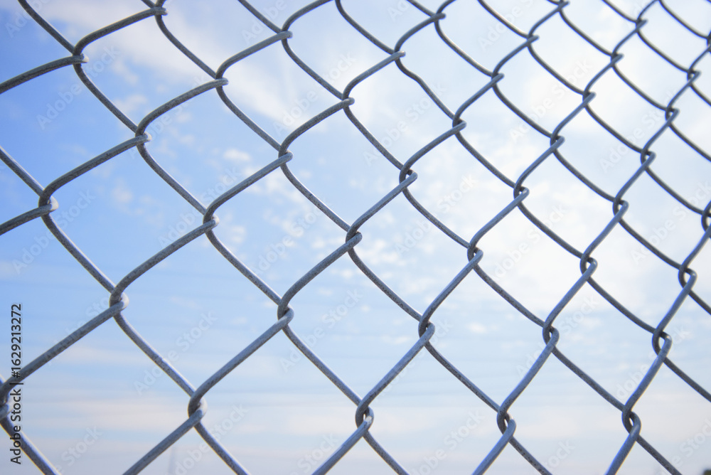 Naklejka premium chain link fence and blue sky