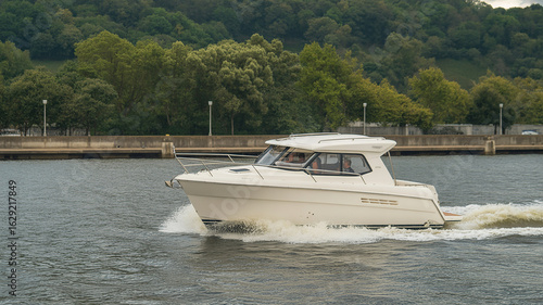 Modern white cabin cruiser boat moving through calm water