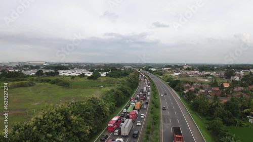 Aerial drone footage of an Indonesian toll road with heavy traffic on one side due to road construction and maintenance. Captured with a forward-moving drone and a slightly downward camera angle