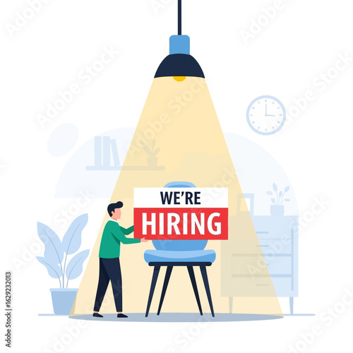 A person places a "We're Hiring" sign on a chair under a spotlight, symbolizing recruitment and job opportunities.