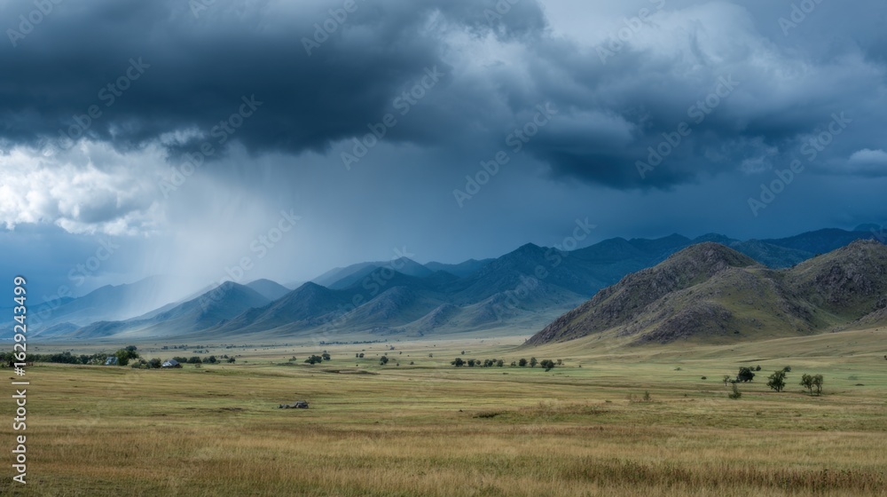 Obraz premium Dark, ominous storm clouds loom over the vast grasslands of Mongolia, creating a dramatic contrast with the distant mountains. Rain begins to fall in the background, suggesting a brewing storm.