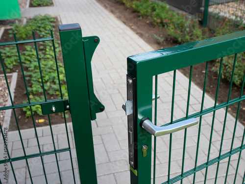 Gartentor geöffnet - Zugang zum Grundstück mit Garten - Metallzaun als Begrenzung und Schutz