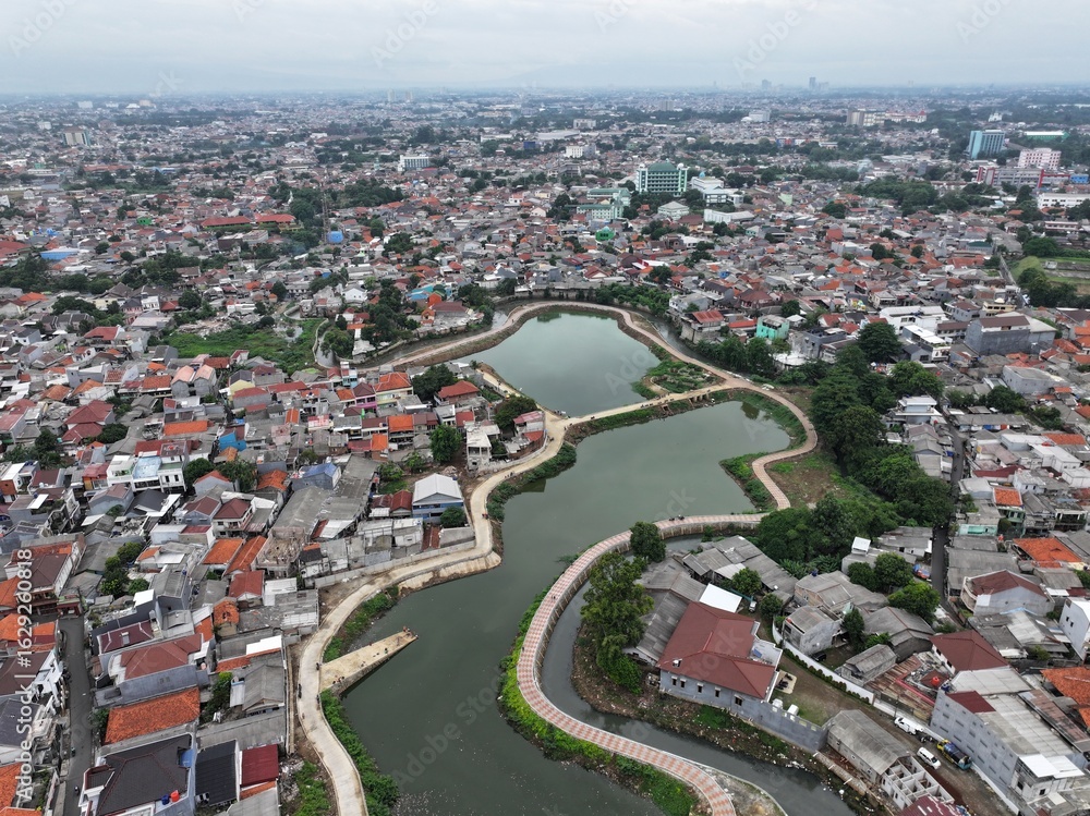 Naklejka premium A beautiful lake with ornamental plants growing on the edge is located in the middle of the city.