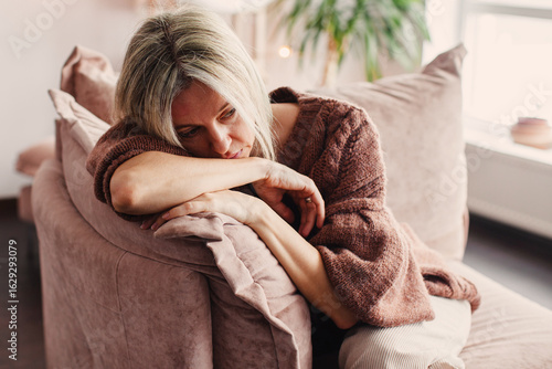 Foto Frustrated Sad Woman sitting on Couch at Home