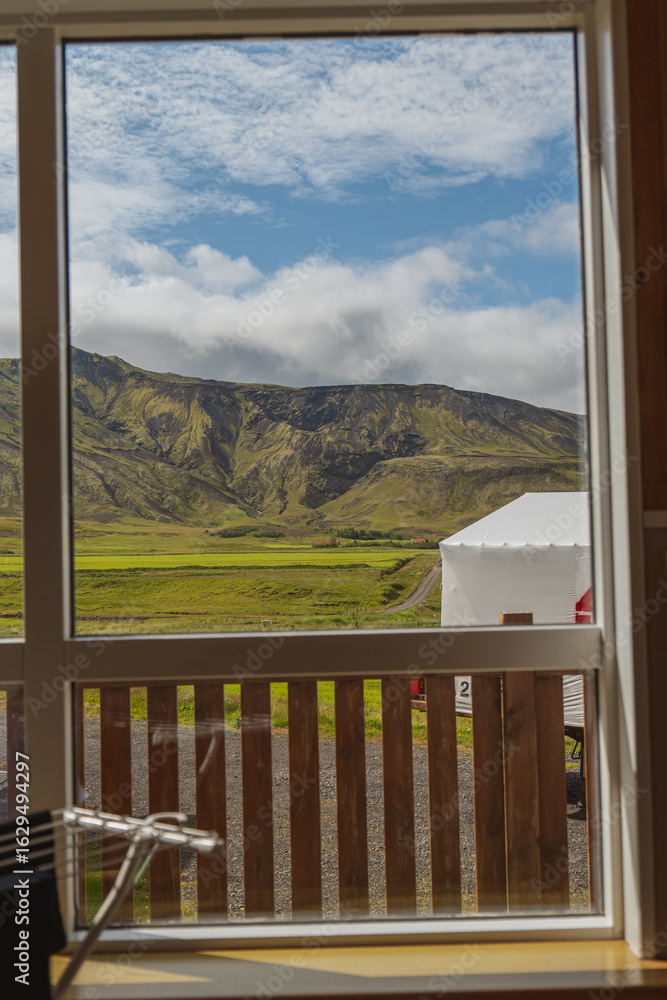 Fototapeta premium Lush Green Valley and Rugged Hills Framed by a Window in Iceland