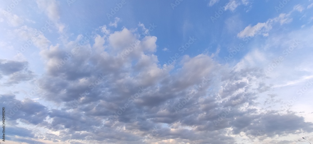 Fototapeta premium Cumulus clouds float across the sky. Beautiful photo of cloudy sky.