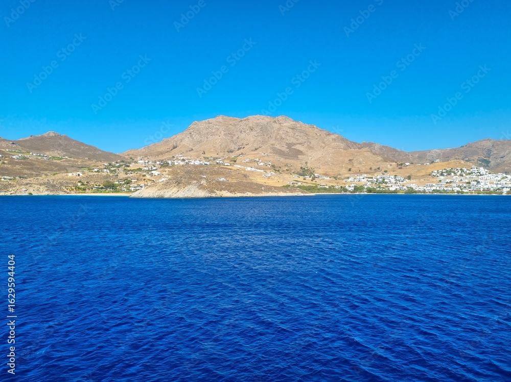 Fototapeta premium Serifos island in Greece in Aegean Sea. Serifos Island in the Southern Aegean Sea with Traditional Whitewashed Houses on Mountain Slopes and Crystal Clear Blue Coastal Waters under Bright Summer Sky