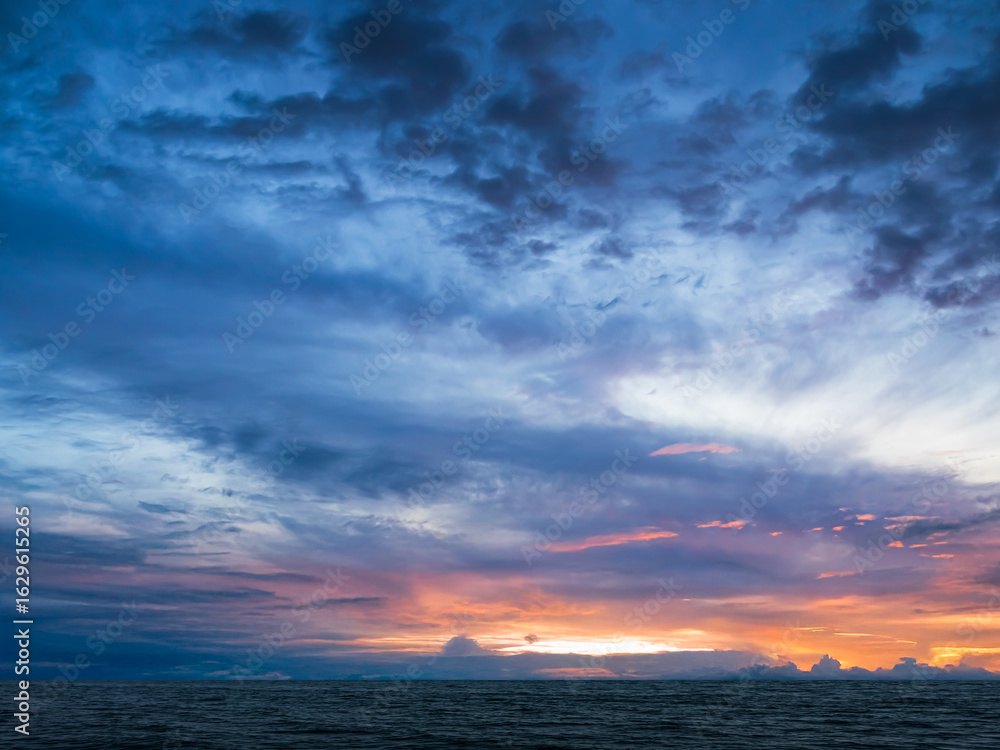 Fototapeta premium Sea sunset sky evening sunrise cloud weather dramatic landscape goldent and indigo color gradient pastel horizon, twilight yellow golden reflection morning nature environment energy ecosystem change.