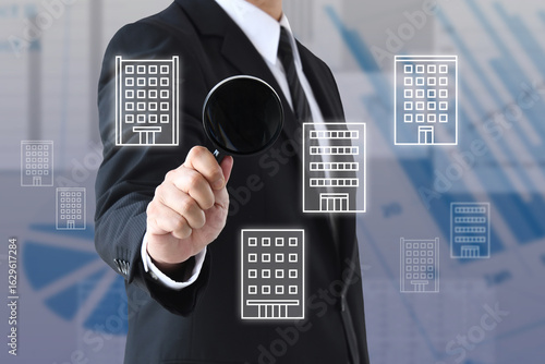 虫眼鏡を使って企業の研究を行うビジネスマン