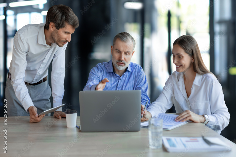 Obraz premium Group of young modern people in formalwear using modern technologies while working in the creative office