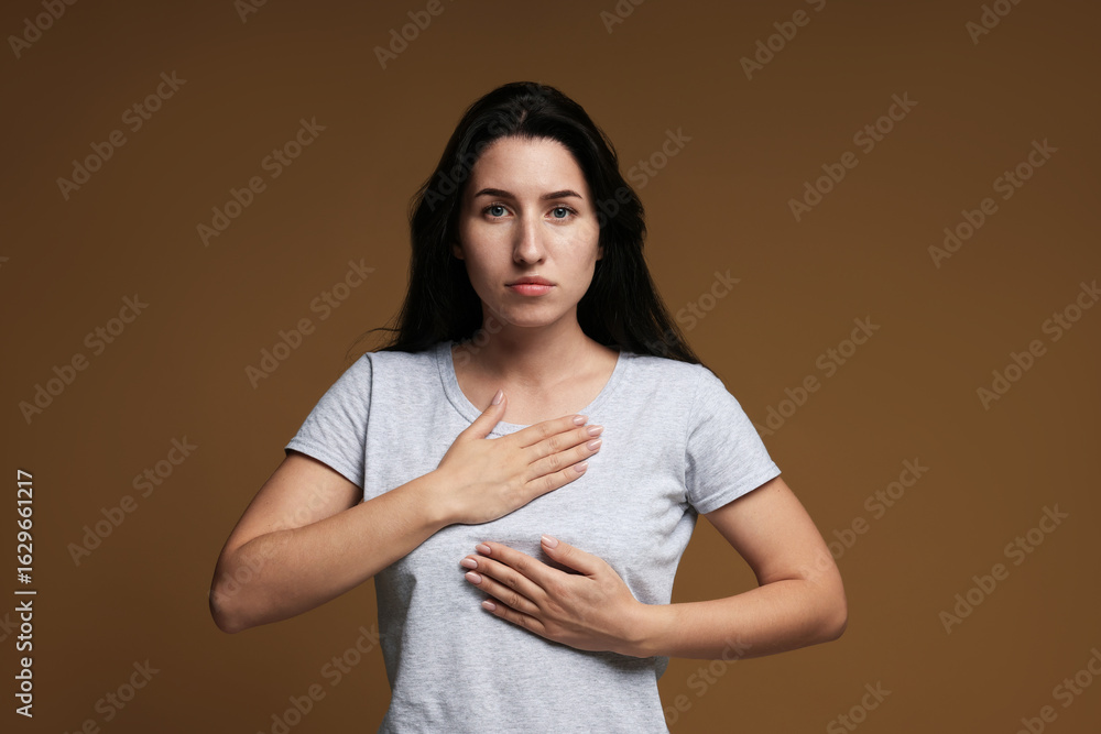 Obraz premium Panic attack. Woman breathing to calm down on brown background