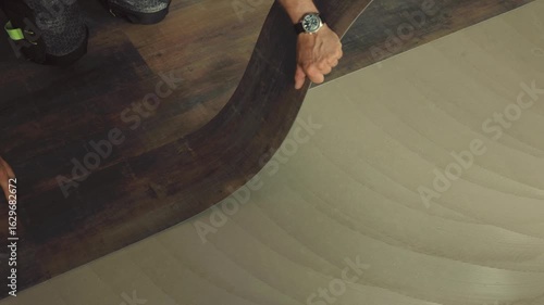 Construction worker installing vinyl laminate flooring