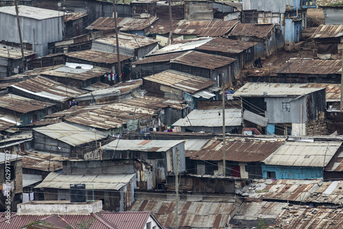 View of corrugated iron roofs of closely packed houses create a textured landscape under a cloudy sky, a stark reminder of urban poverty, Nairobi, Nairobi County, Kenya.