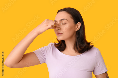 Young woman touching her no...
