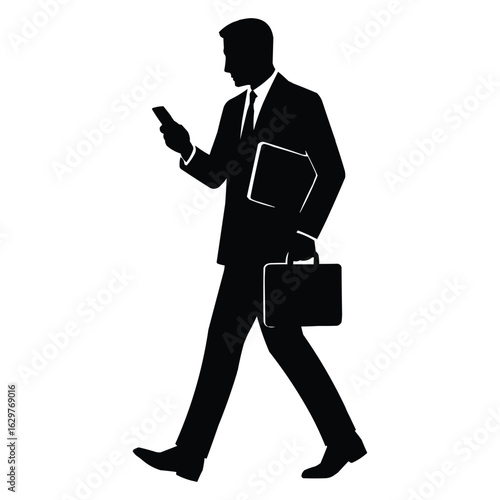 A businessman in a suit walking while looking at his smartphone and carrying a briefcase and folder a striking silhouette