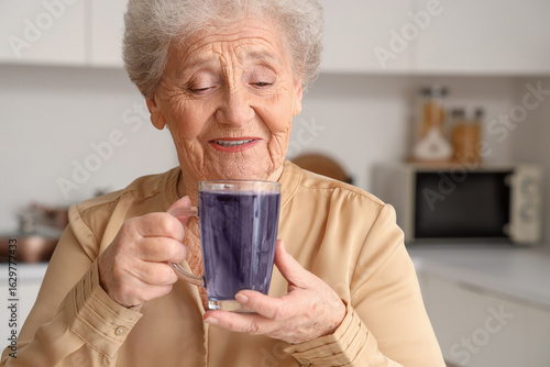 Senior woman with glass cup...