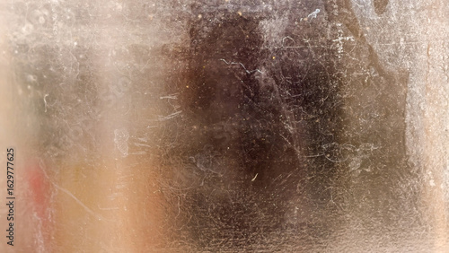 An abstract textured look through the dusty glass dirt, revealing faded colors and blurred reflections.