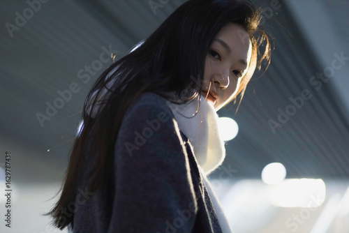 Asian woman with long hair in soft lighting.