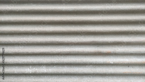 Fragment of old roof with wavy asbestos cement roof tile, Full frame shot of patterned textile.Frozen roof with moss and leaves