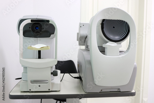 Ophthalmic diagnostic devices: non-contact tonometer and corneal topographer side by side. Used for measuring eye pressure and mapping corneal shape in eye care clinics.