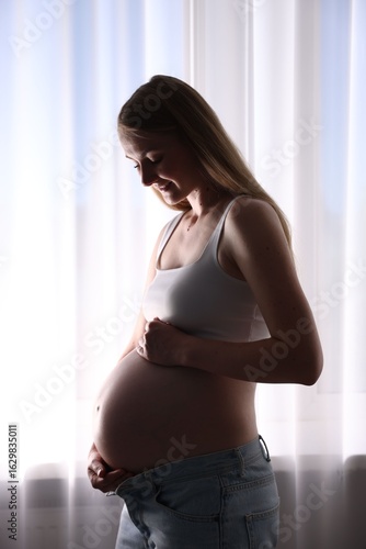 Beautiful pregnant woman near window at home Free Download Beautiful pregnant woman near window at home - GFXLoad