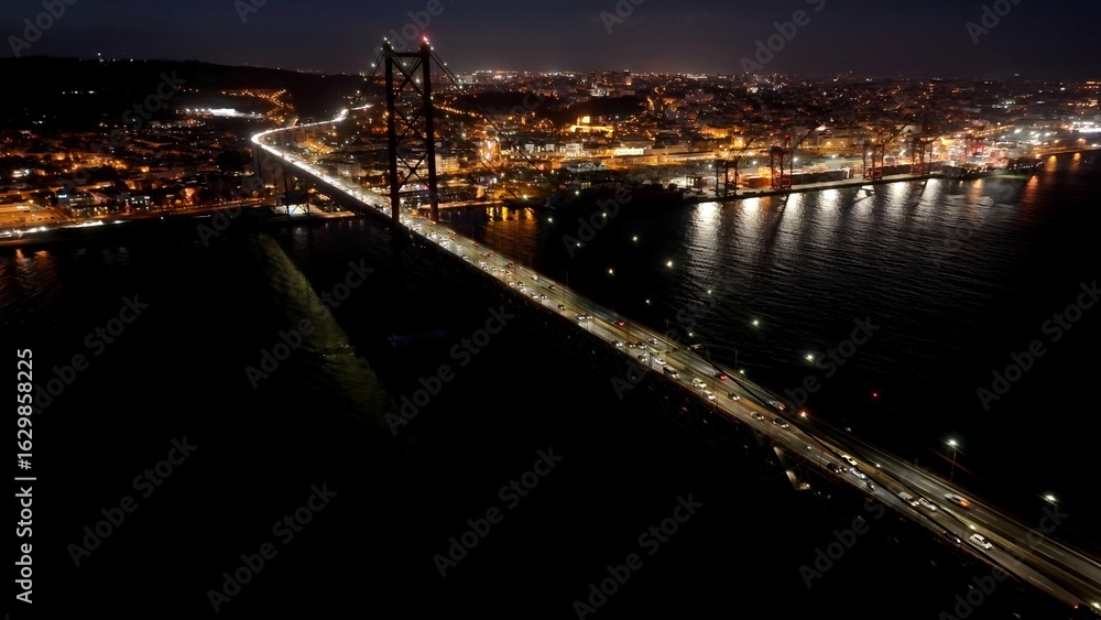 Fototapeta premium Night 25Th April Bridge In Lisbon Portugal. Aerial View Of Landmark Bridge Showcasing Its Intricate Design . Building Infrastructure Landscape Buildings Vibrant. Infrastructure Corporate.