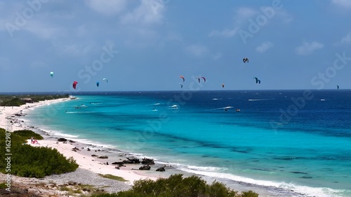 Kiteboarding Bonaire In Kralendijk Bonaire Netherlands Antilles. Tourists Parasailing Over A Tropical Ocean On A Sunny Day. Paradise Landscape Idyllic Amazing. Paradise Coast. Kralendijk Bonaire.
