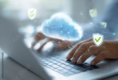 Hands typing on laptop with glowing cloud and security shields symbolizing cloud computing and data protection