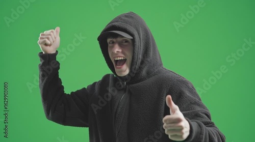  young man giving thumbs up and smille winning reaction wearing hood 