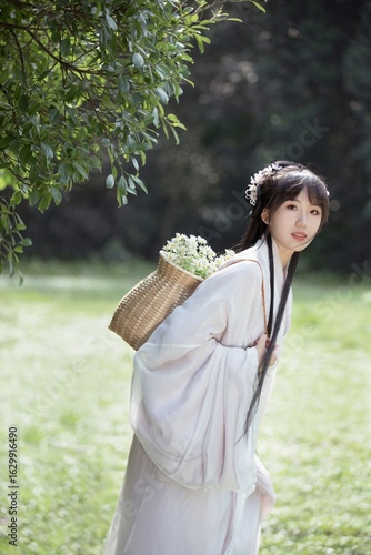 Young woman in traditional attire with flowers in a basket.