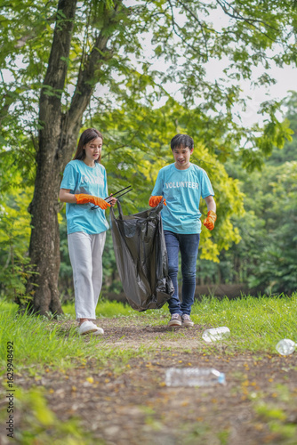 Obraz na plátně team of volunteers collecting and sorting garbage at the public park