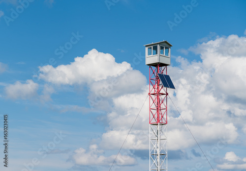 A tall fire tower against a cloudy sky.