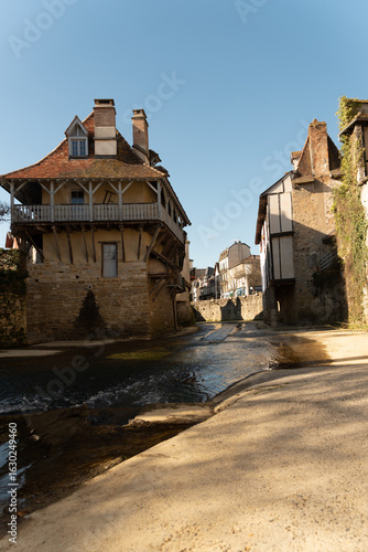 Obraz na plátně Peaceful river scene in Salies-de-Béarn with houses and traditional bridge, Fran