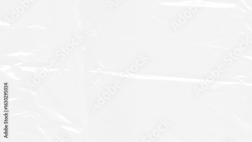 Abstract textured background of crumpled, transparent plastic wrap, creating a pattern of highlights and shadows