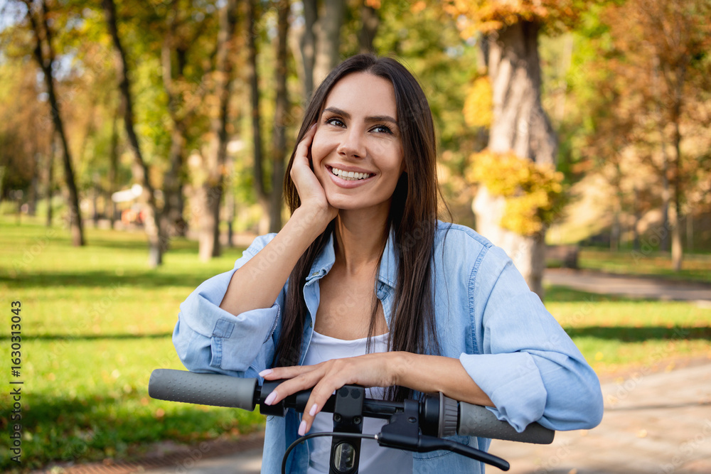 Φωτογραφία Happy woman enjoying weekend free day while riding on ecteronic scooter, she traveling resting relaxing in city park nature forest