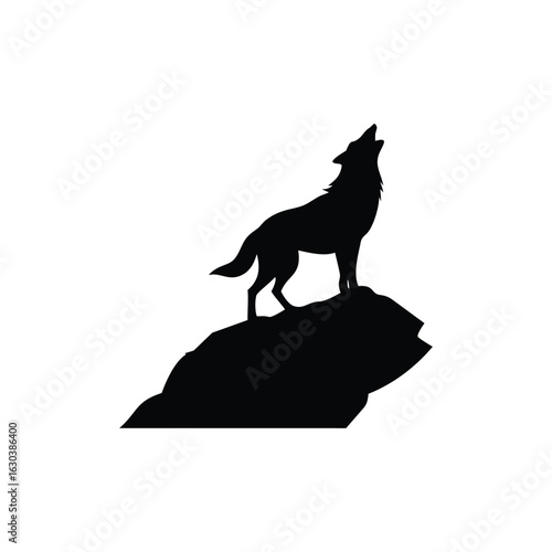 Silhouette of a wolf howling on a rocky outcrop